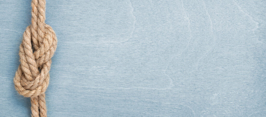 Ship rope knot on blue wooden texture background