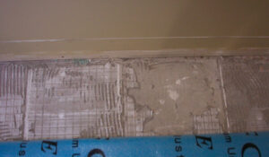 The installer removed some boards in the entrance area, which revealed some thin set was left on the concrete where they removed ceramic tile. 