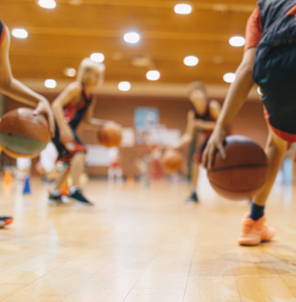 Young Basketball Player on Practice Session. Youth Basketball Team Bouncing Balls on Sports Court. Group of Kids Training Basketball Together