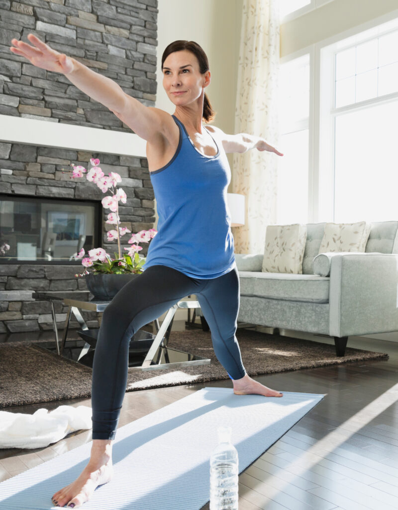 Mature woman stretching on yoga mat