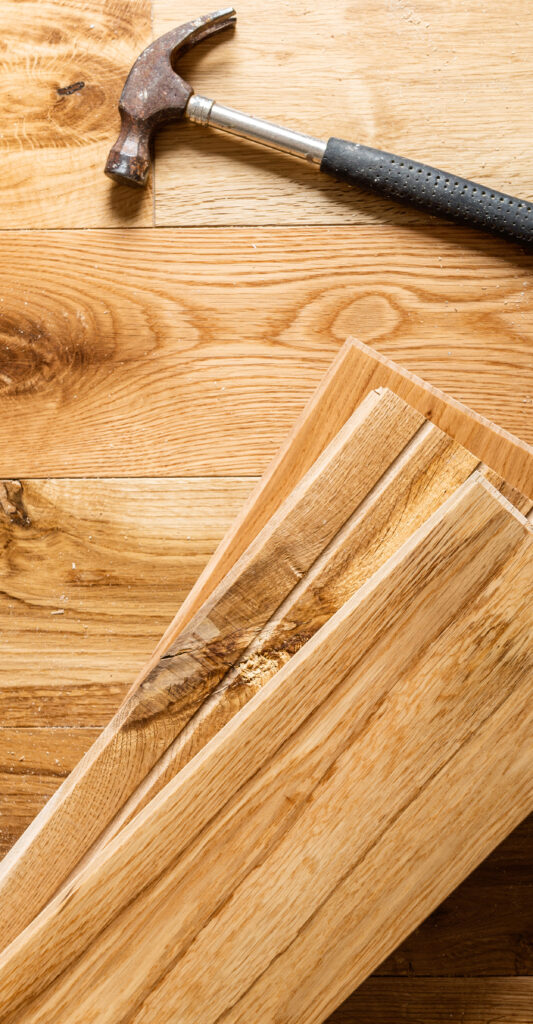 The process of house renovation with changing of the floor from carpets to solid oak wood. Different tools and materials on the new floor