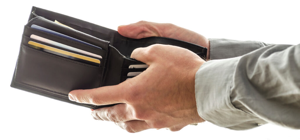 A man opening his  wallet to pay for something. 