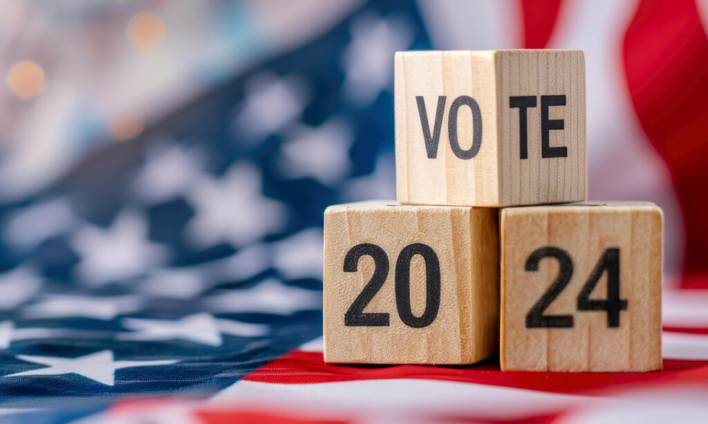 United States presidential election in 2024. Wooden cubes with text VOTE and 2024 over the American flag background