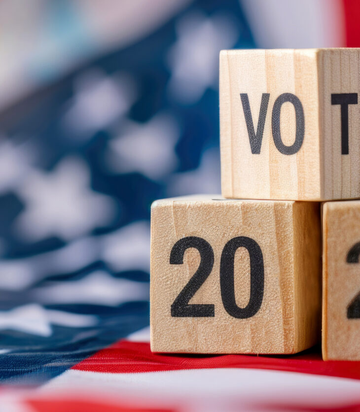 United States presidential election in 2024. Wooden cubes with text VOTE and 2024 over the American flag background